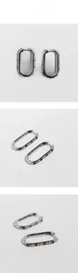 Detailed views of silver U-shaped earrings with colorful inlaid zircon gemstones