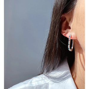 Silver U-shaped hoop earrings with colorful zircon stones on female model ear