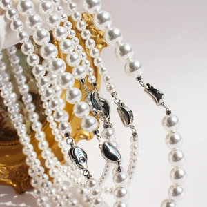 Elegant white pearl necklace with S925 sterling silver clasp on a gold frame