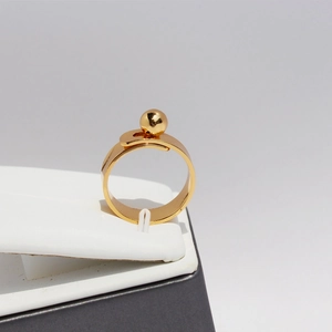 Minimalist gold ball geometric ring featuring a polished wide band and modern open style