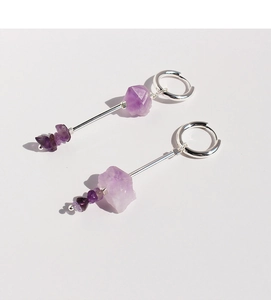 Macro detail of minimalist silver drop earrings with natural purple amethyst stones