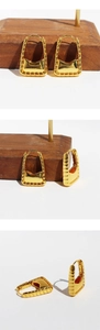 Detailed close-up showing 24k gold plated rectangular hoop earrings with stripe texture