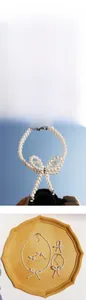 Detailed view of white pearl jewelry set with bow designs on yellow geometric tray