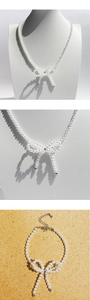 Detailed view of pearl necklace featuring a bowknot pendant and silver lobster clasp closure