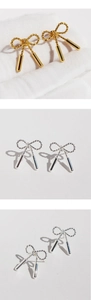 Macro shot of twisted rope bow earrings featuring smooth cylinder drop details in gold and silver