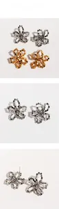 Detail of handmade woven metallic bead flower earrings in gold and silver finishes