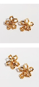 Detailed macro view of handmade gold beaded flower earrings with metallic luster
