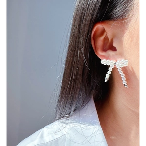 Elegant pearl bow earrings featuring high-quality white beads and silver metal details