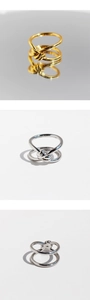 Close-up of minimalist gold and silver double-layered knot rings with polished mirror reflection