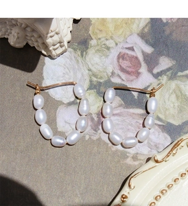 Vue détaillée des boucles d'oreilles en U en or avec perles d'eau douce faites à la main
