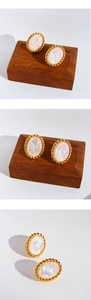 Gros plan sur des boucles d'oreilles ovales vintage avec pierre opale et bordure dorée