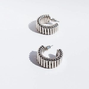 Silver metallic C-shaped wavy ribbed hoop earrings with unique vertical tubular texture