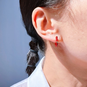Luxe red enamel hoop earrings for women with inlaid zircon shown on ear profile