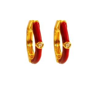 Gold hoop earrings with red enamel and central zircon stone on white background