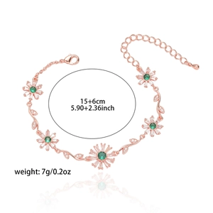 Detail view of flower bracelet with green stone heart and rose gold leaf texture