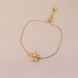 Detail of adjustable gold flower bracelet with pink zircon petals and box chain