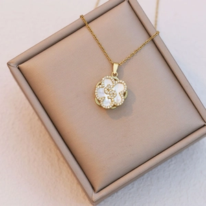 Gold five-petal flower necklace with mother-of-pearl, zircon stones, and dollar sign pendant