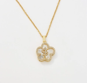 Detail of gold flower necklace with dollar sign pendant and pavé zircon stones