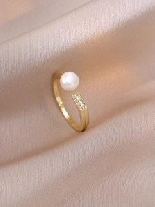 Detailed view of adjustable gold-plated ring with a pearl and pave zircon stones on silk