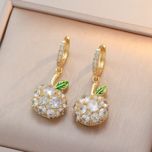 Boucles d'oreilles pommes dorées avec cristaux et feuilles vertes sur velours champagne