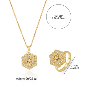 Parure fleur dorée avec collier flocon en zircon et bague rotative sur fond blanc
