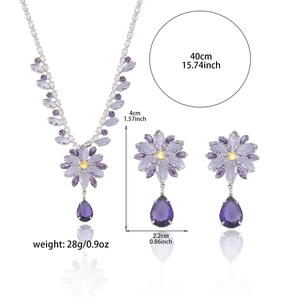 Parure de bijoux avec fleurs mauves et cristaux de zircone sur fond blanc pur