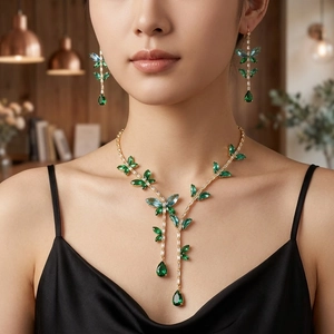 Elegant gold jewelry set with green emerald butterfly necklace and matching earrings