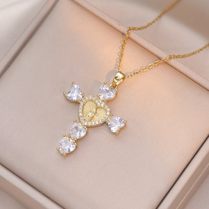 Detail of gold cross pendant with heart-shaped zircons and Mary relief in a jewelry box