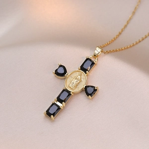 Close-up of gold cross necklace featuring black zircons and a Virgin Mary medallion