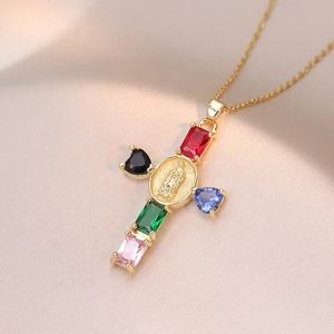 Detail of gold cross pendant with colorful zircon stones and Mary relief on satin