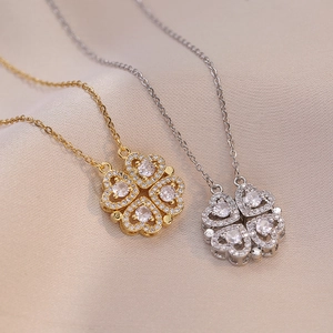 Détail de colliers trèfles en or et argent avec pétales en cristal en forme de cœur