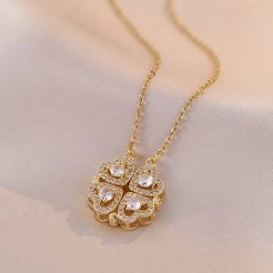Détail du collier trèfle doré avec quatre cœurs sertis de cristaux brillants et fins