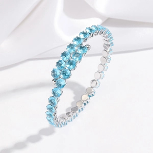 Détail du bracelet bypass argenté orné de pierres de zircon bleu clair serties à griffes