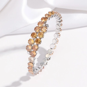 Gros plan d'un bracelet ouvert serti de cristaux de zircone cubique orange vif