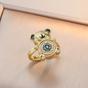 Golden bear ring with blue stone and colorful zircon inlays on a champagne stand