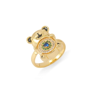 Detail of golden bear ring featuring blue center stone and zircon accents on white background