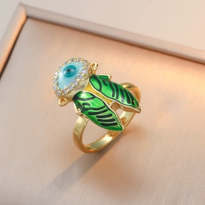 Détail macro de bague insecte avec ailes en émail vert et pierre œil bleu