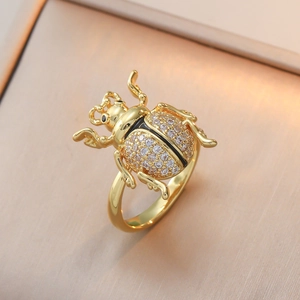 Détail macro d'une bague scarabée dorée montrant des diamants pavés et des ailes d'insecte