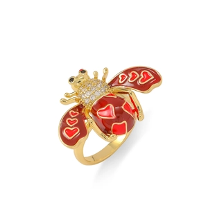 Détail d'une bague abeille dorée avec ailes en cœur émaillé rouge et oxydes de zirconium