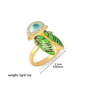 Détail macro de la bague cigale avec ailes en émail vert et pierre œil bleu porte-bonheur
