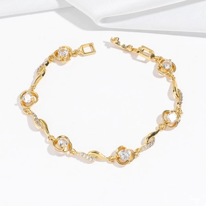 Dettaglio del bracciale dorato a maglie con zirconi scintillanti e design tondo cavo