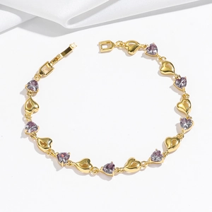 Dettaglio del bracciale dorato a forma di cuore con zircone viola e chiusura a scatto