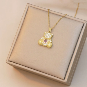 Détail du pendentif ours doré avec trèfle rose et cristaux de zircone scintillants