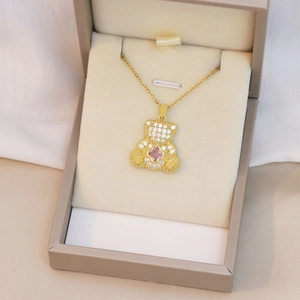 Détail du pendentif ours doré avec zircons étincelants et gemme de fleur rose