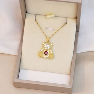 Détail du collier ourson orné de strass brillants et d'un trèfle rouge central
