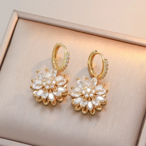 Boucles d'oreilles créoles fleurs dorées avec zircons marquise sur boîte en satin