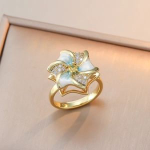 Elegant gold flower ring with blue and white enamel petals and sparkling yellow zircon