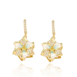 Detailed view of gold flower earrings with blue enamel and sparkling zircon stones