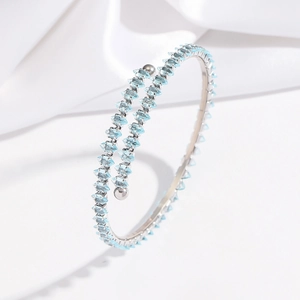 Détail d'un bracelet spirale argenté orné de cristaux bleu ciel de taille marquise