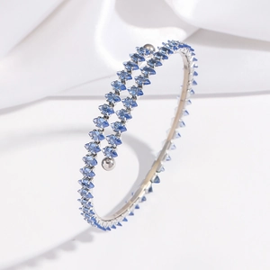 Vue macro de cristaux bleus taille marquise sur un bracelet double spirale en acier